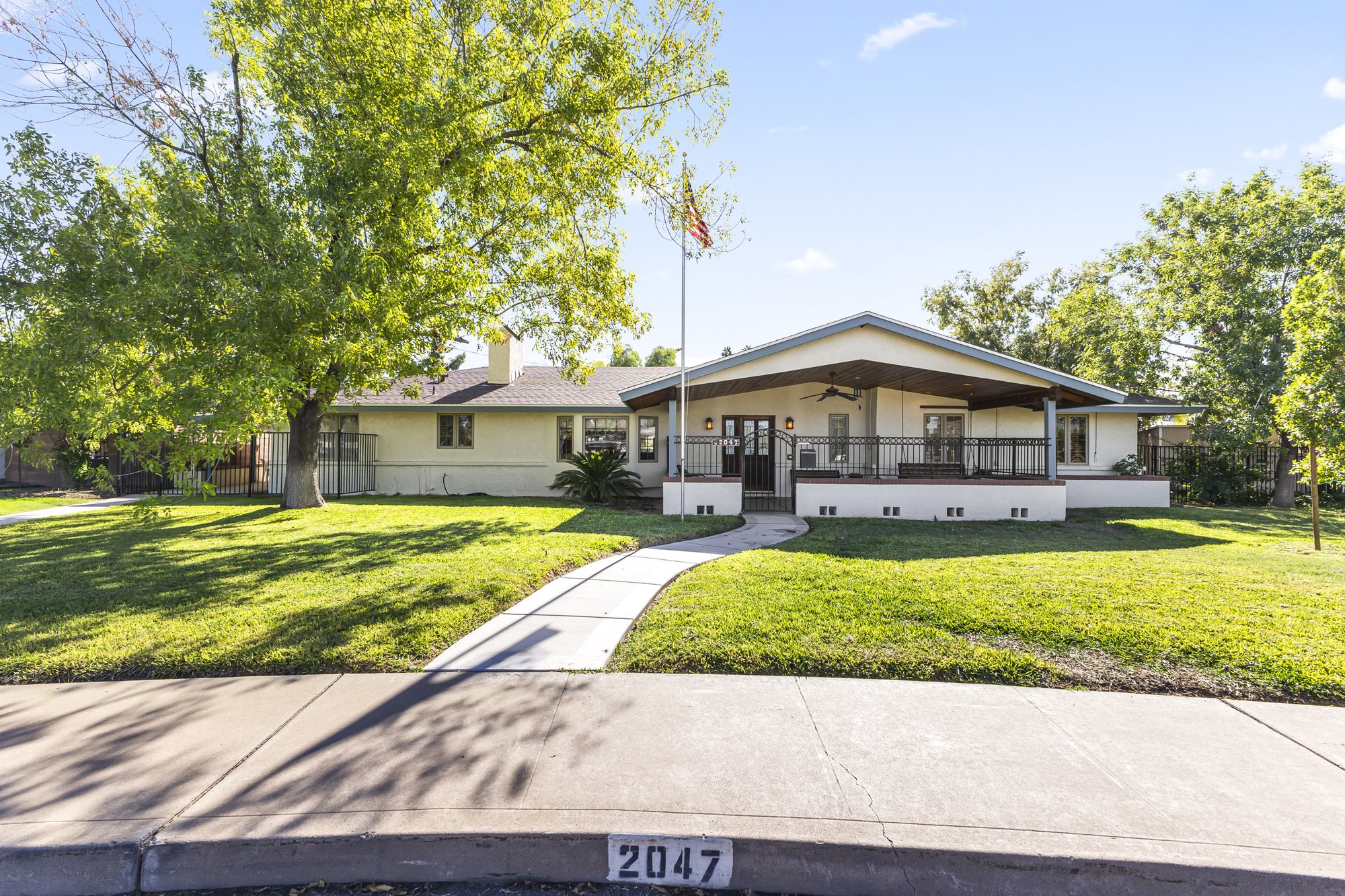 Front yard with mature grass and trees