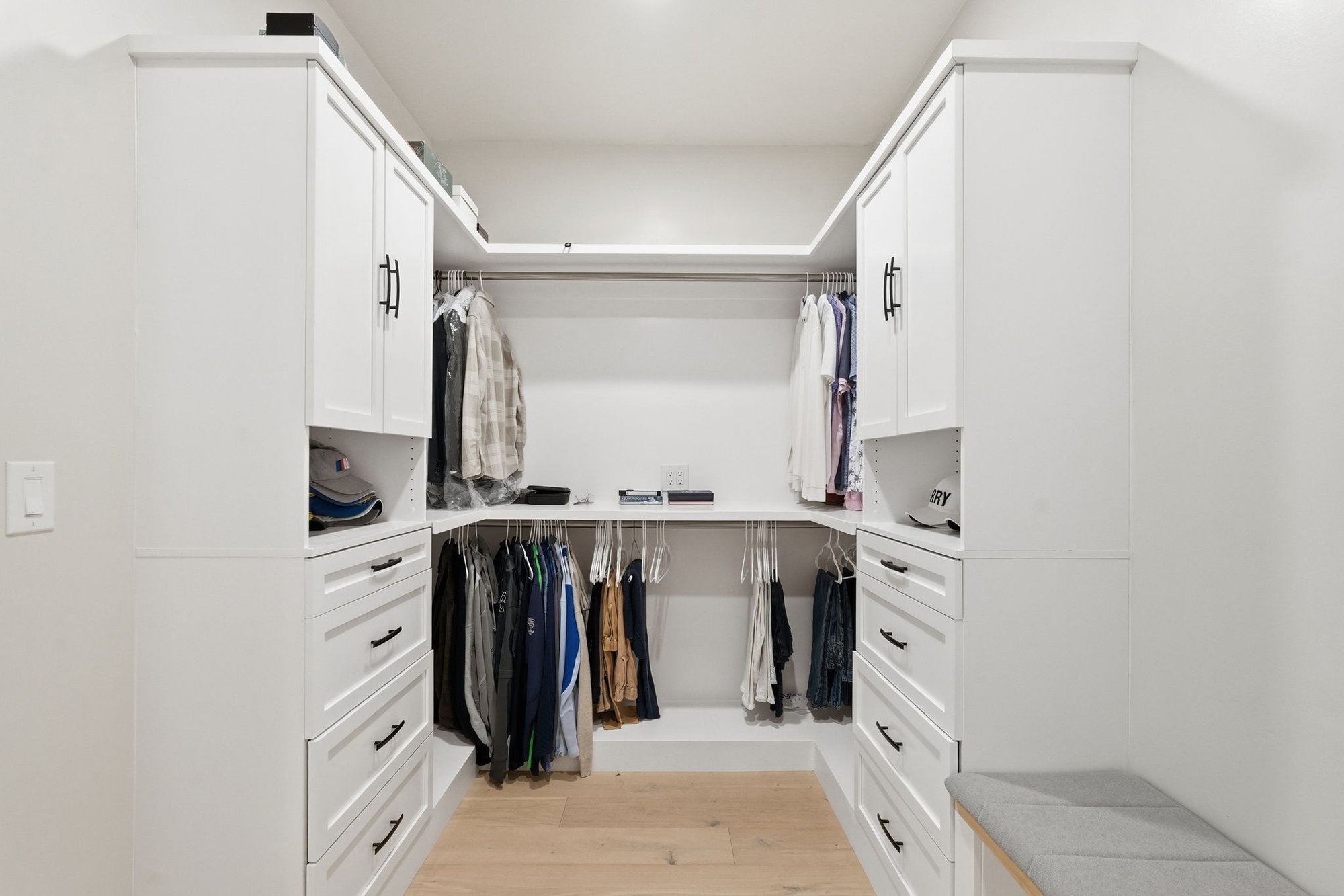 Primary walk in closet with built in shelving