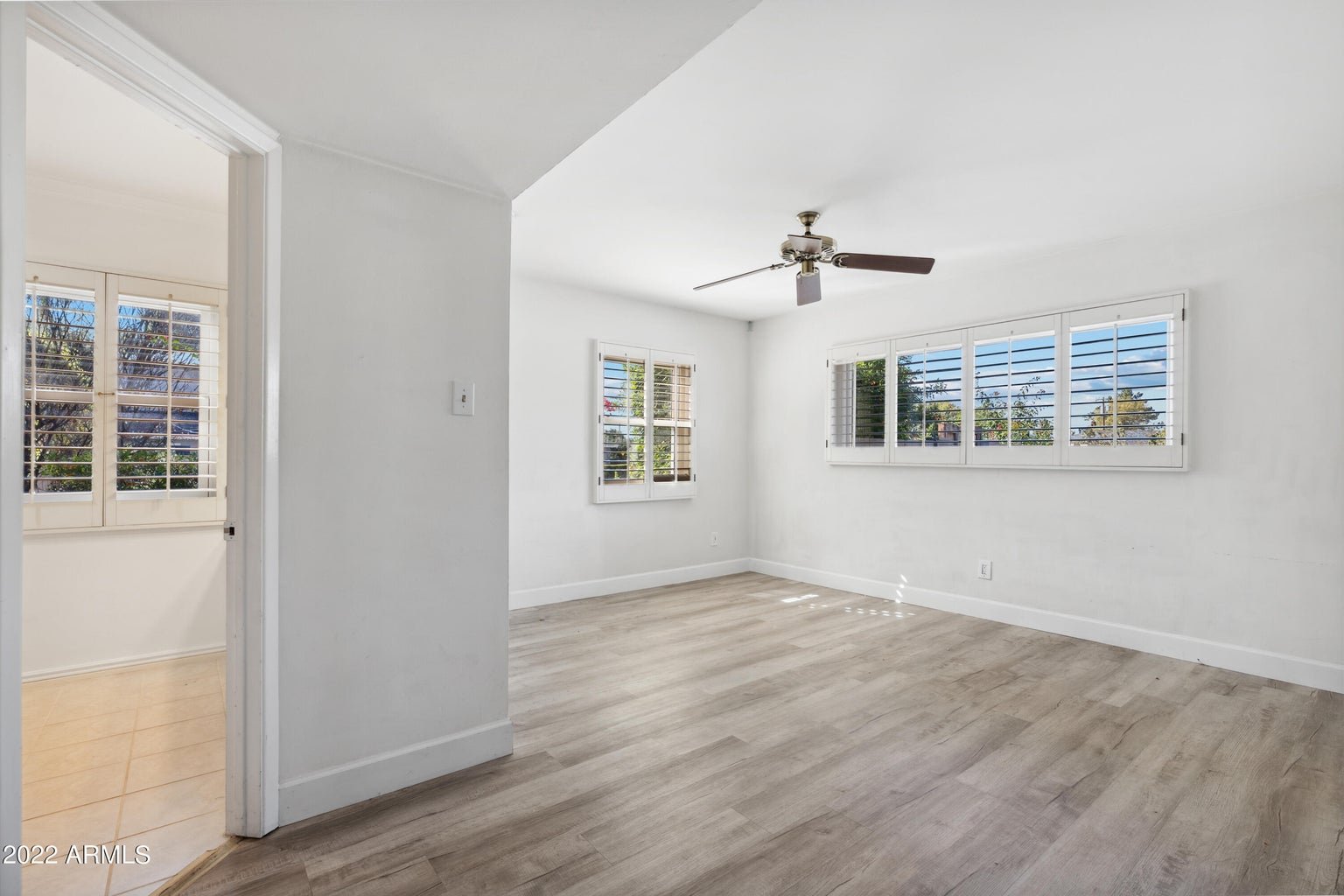 Primary bedroom with a ceiling fan and natural light