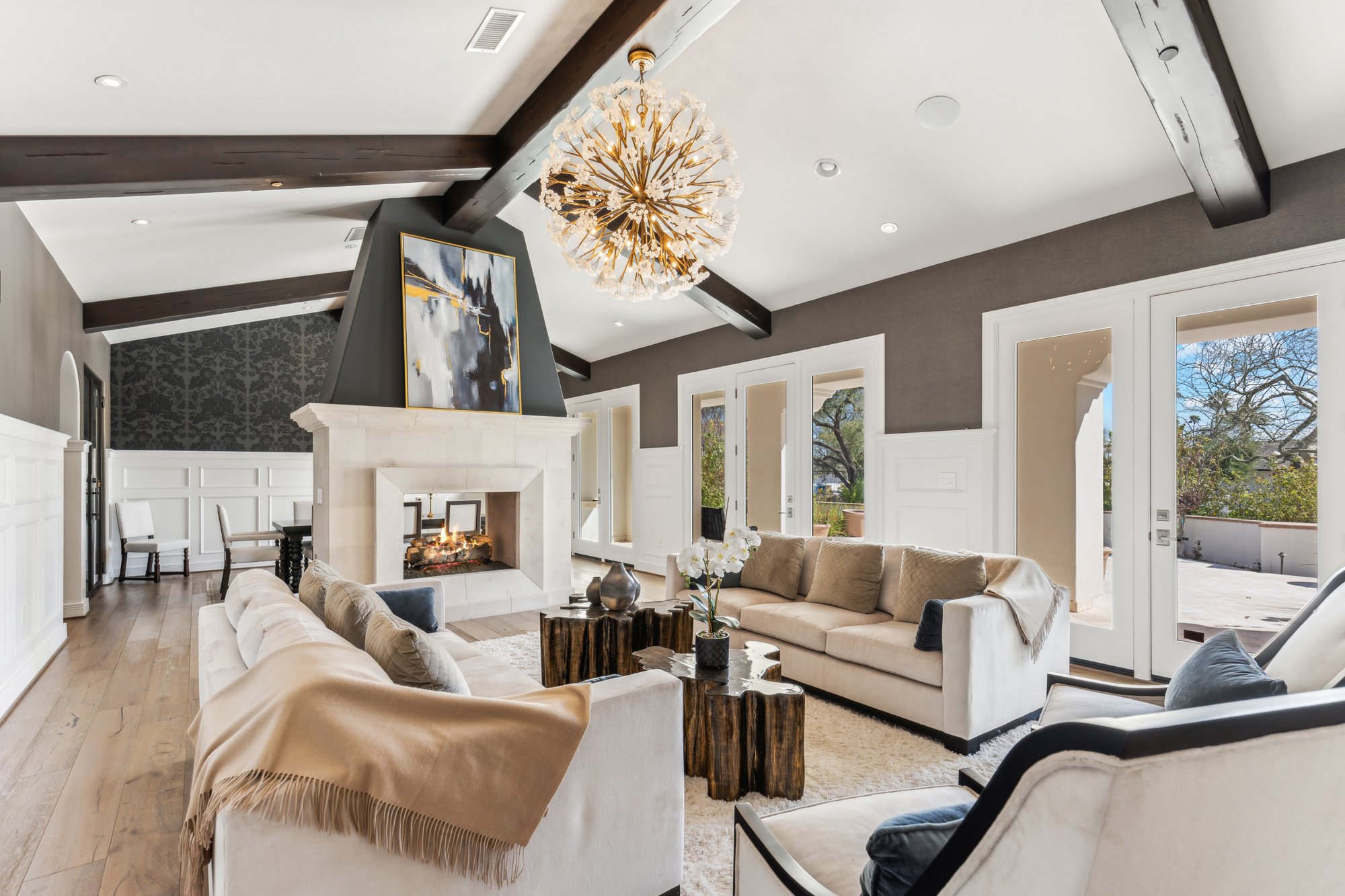 Formal living room with vaulted ceiling, chandelier, and fireplace