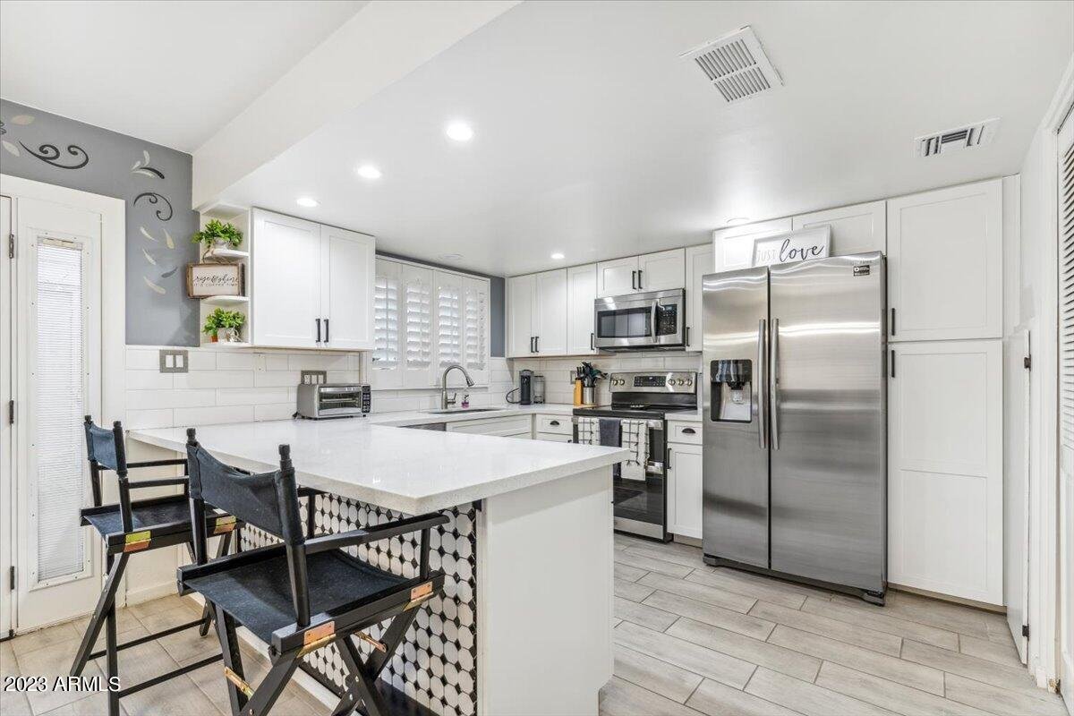 Kitchen with island seating and stainless steel appliances