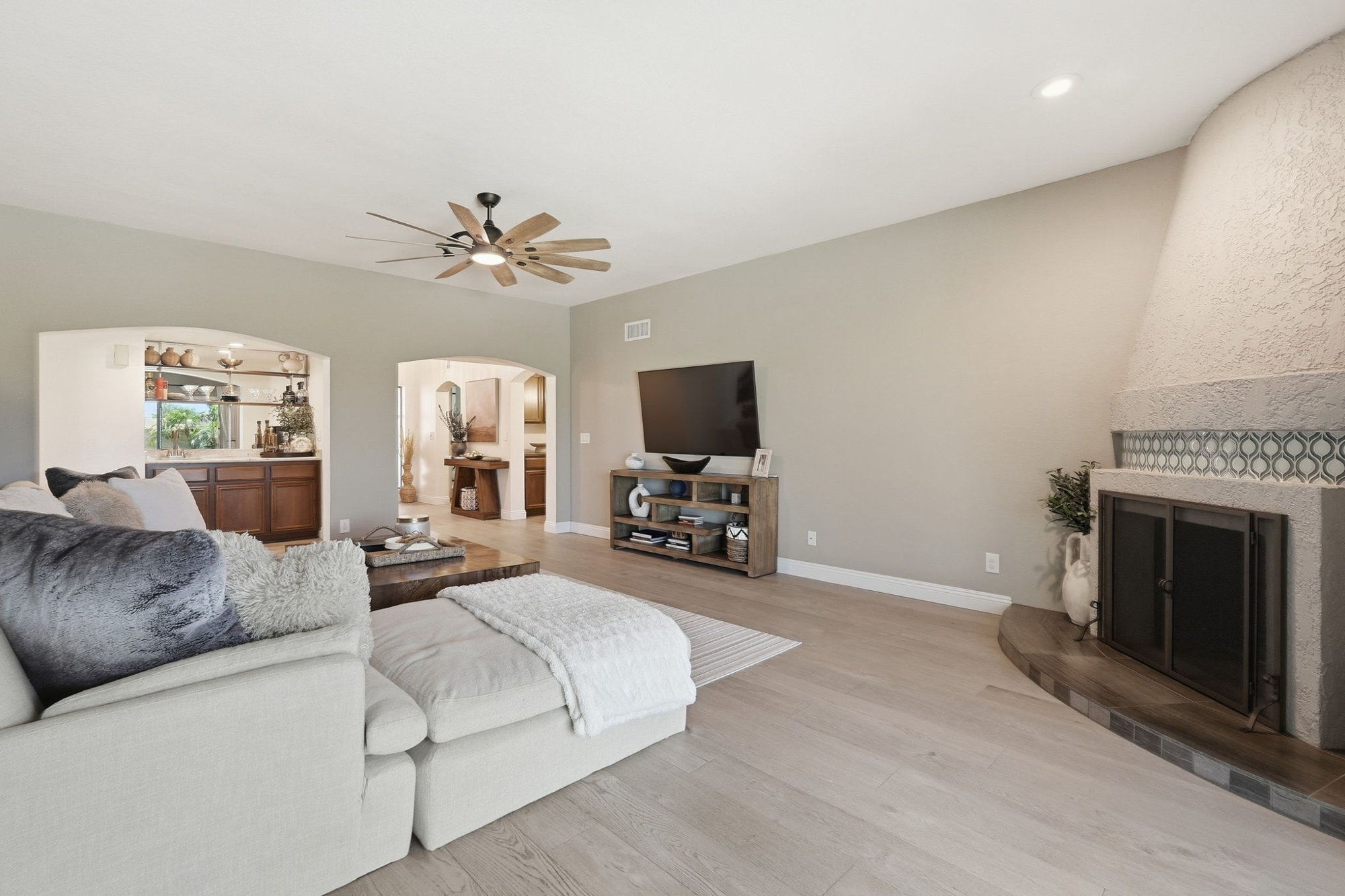 Living room with a wood-burning fireplace and wood flooring