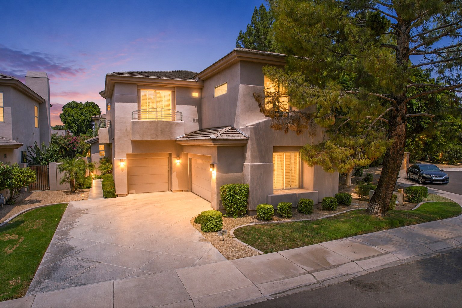Front exterior of 7380 E Vaquero Dr at dusk with a three car garage