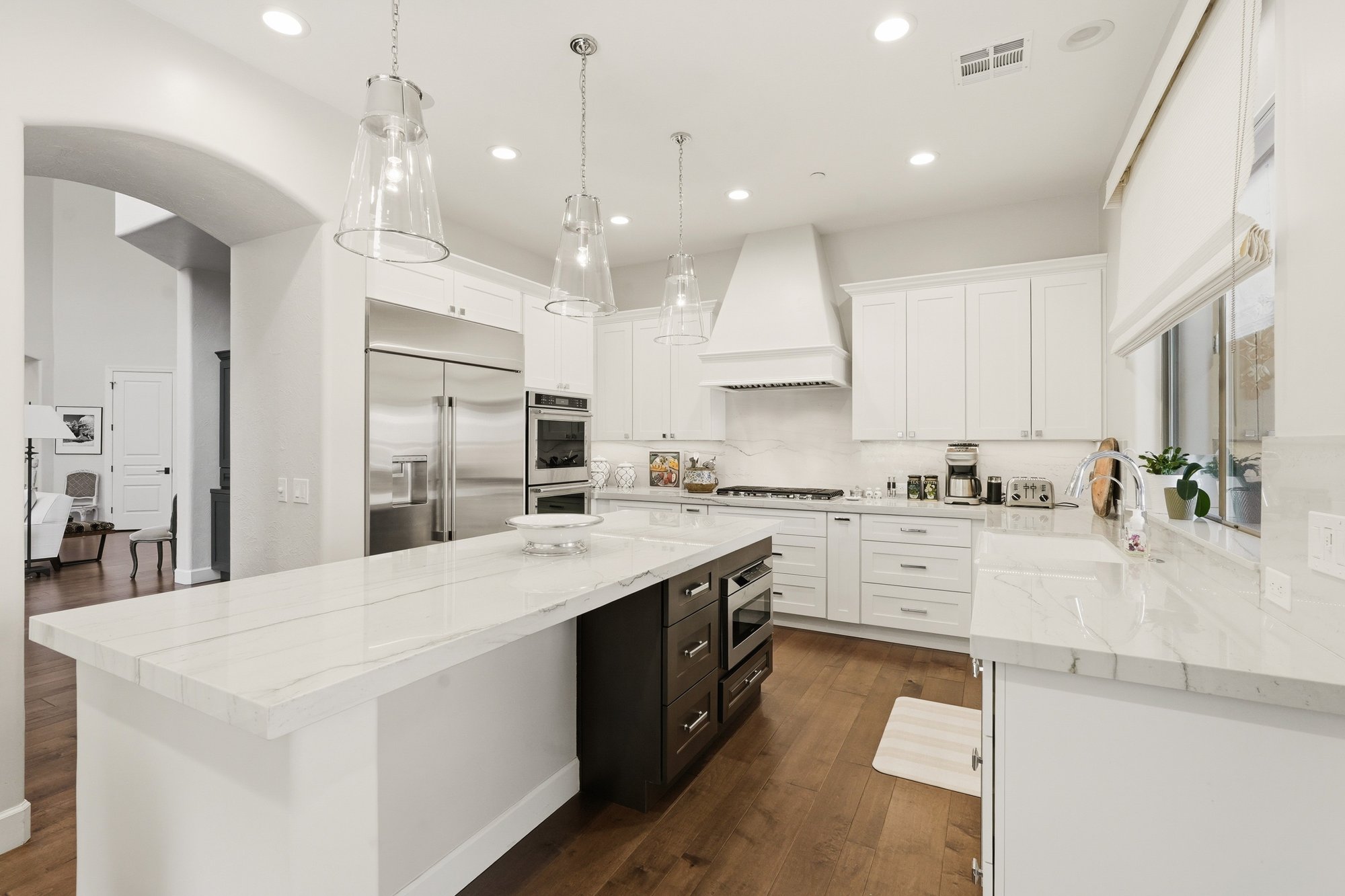 Renovated kitchen island with pendant lighting and granite counters