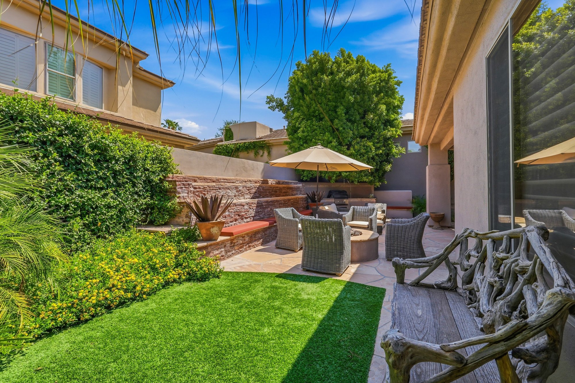 Twilight patio at 7380 E Vaquero Dr with a fire feature and lush landscaping