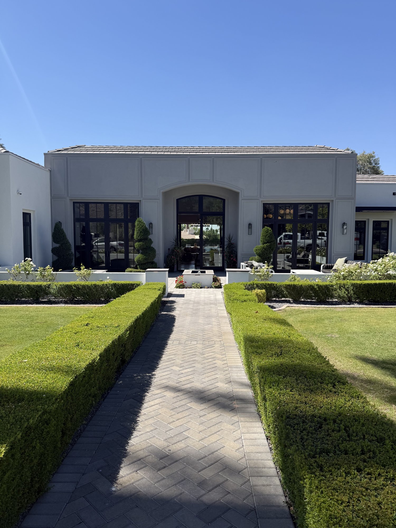 Front facade of a recent Arcadia home with manicured hedges and a paver walkway