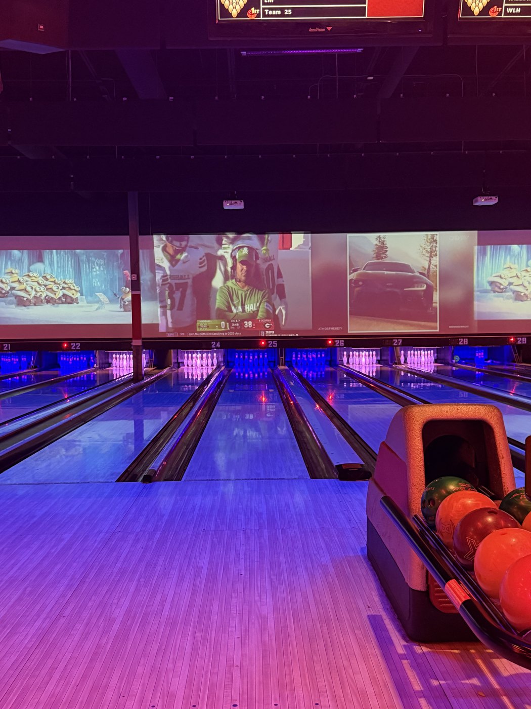 Bowling lanes lit up in purple light at a bowling alley