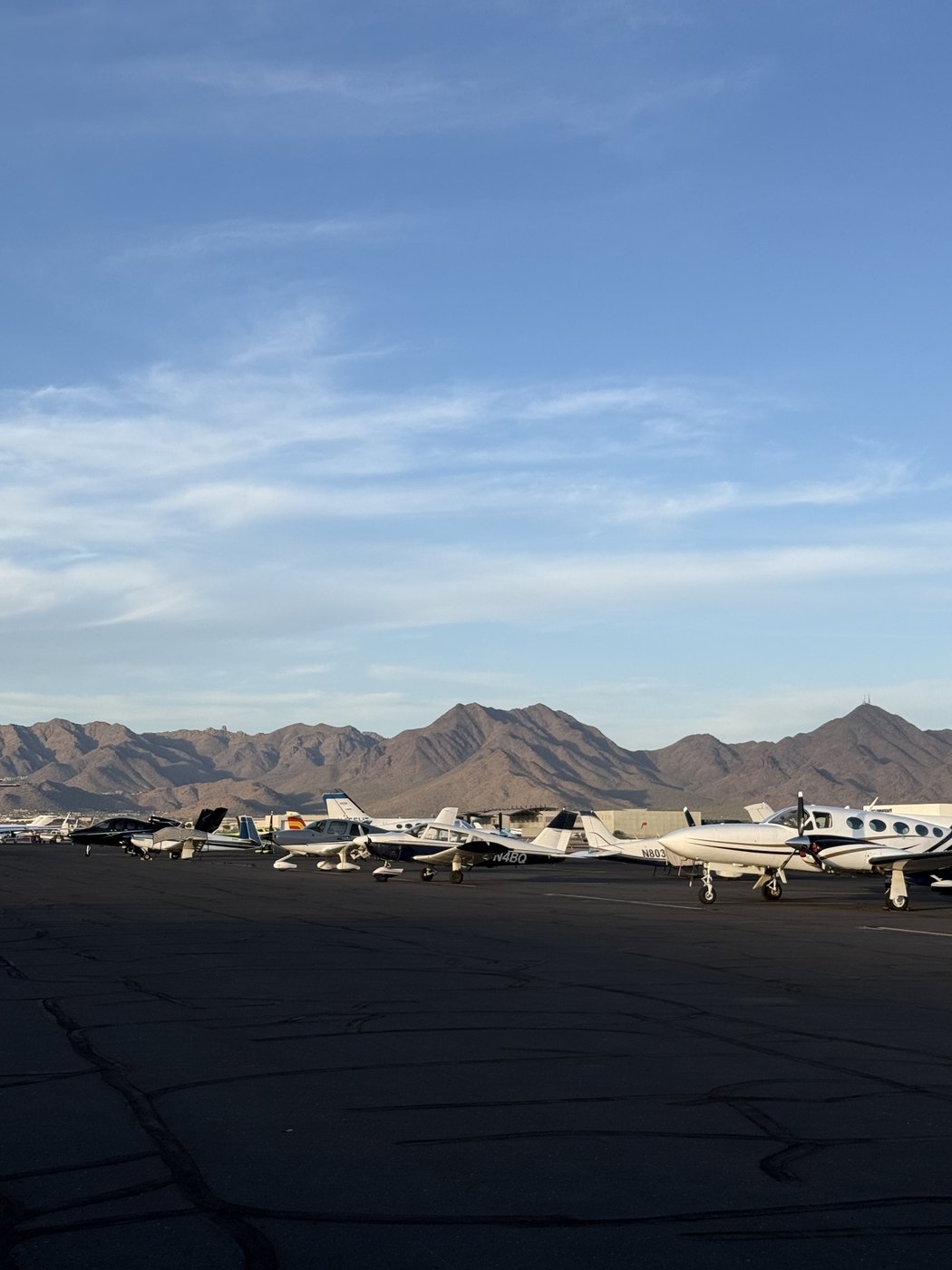 Small aircraft parked on the tarmac with Arizona mountains in the background
