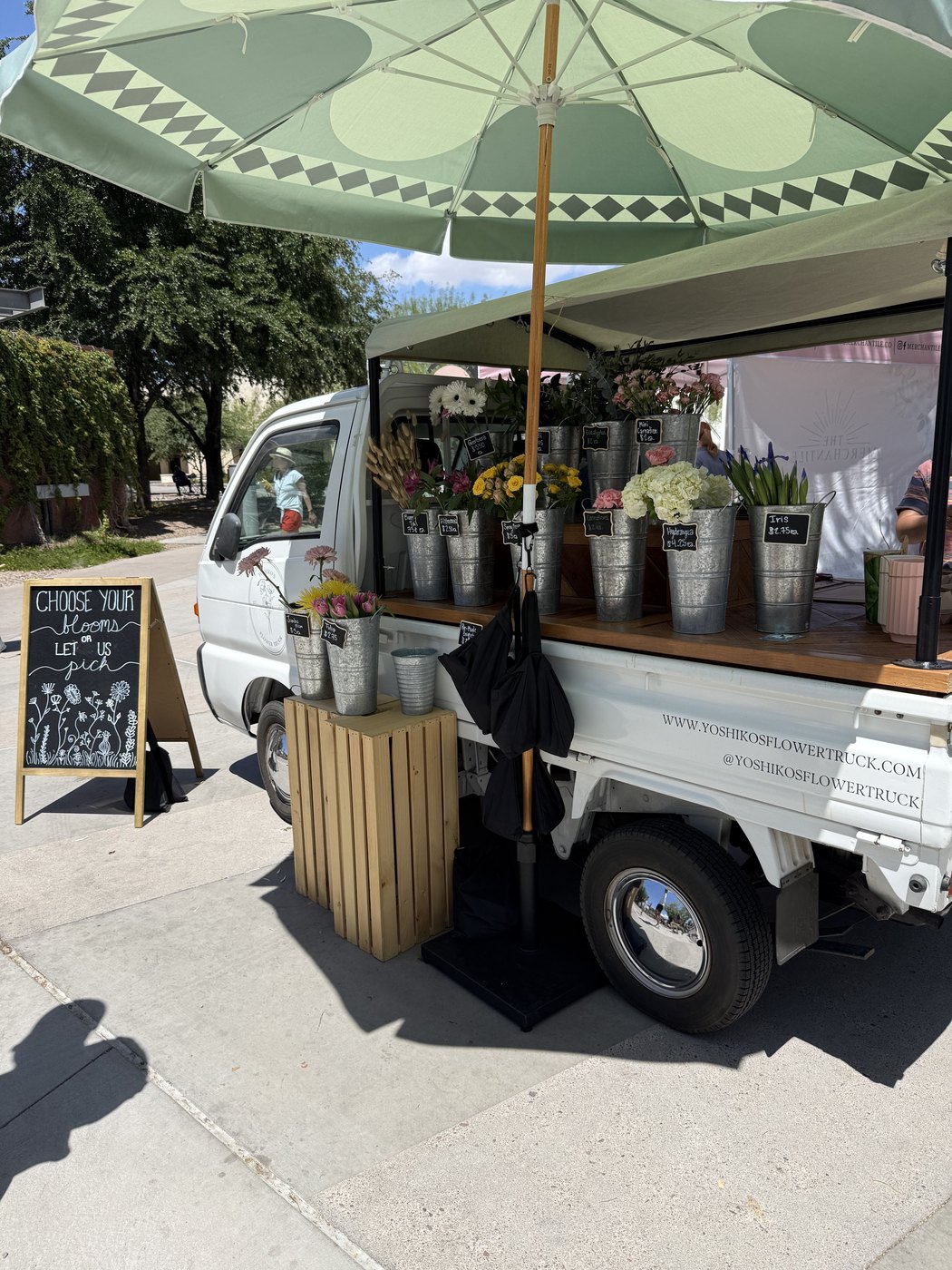 A flower truck with buckets of fresh cut flowers for sale