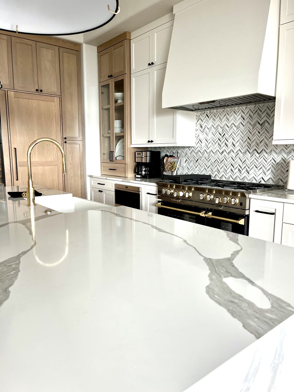 Luxury kitchen with a brass range and waterfall quartz island, North Phoenix